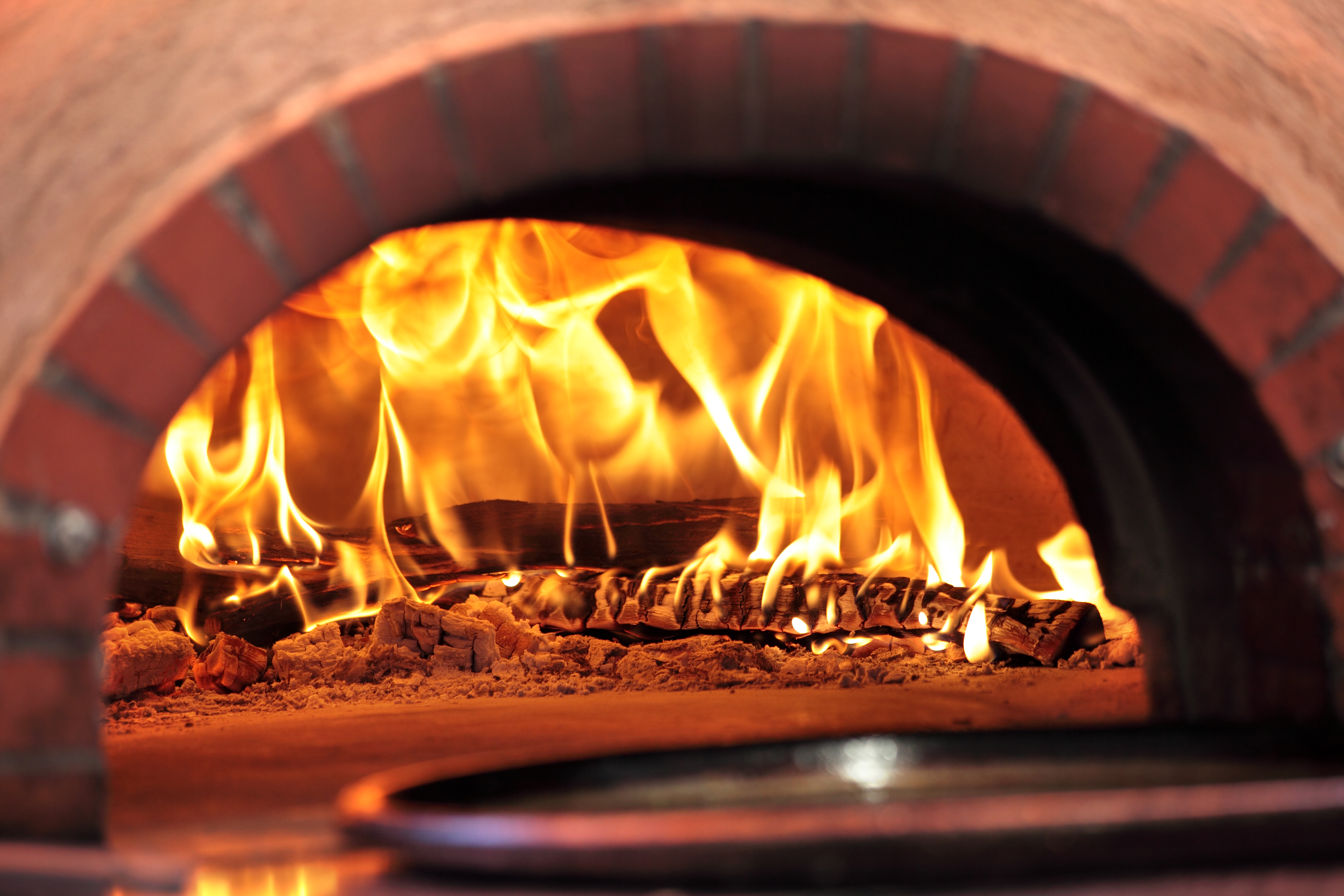 flaming hot wood-fired pizza oven